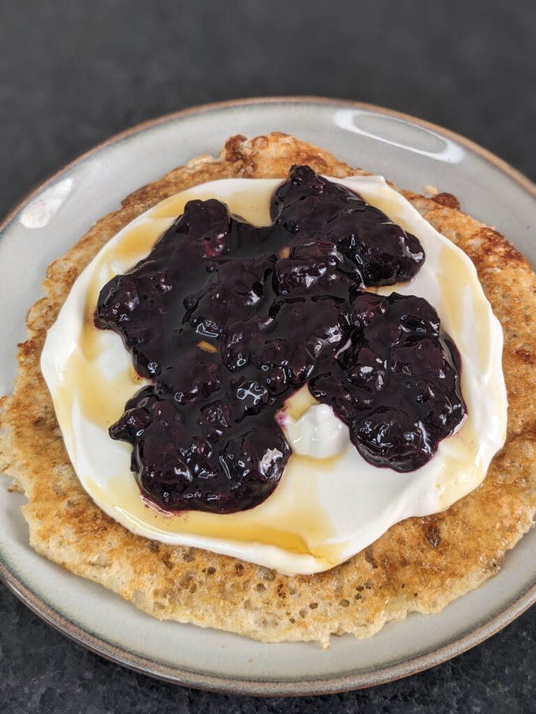 4 ingredient cottage cheese pancakes topped with Greek yogurt and blueberry sauce